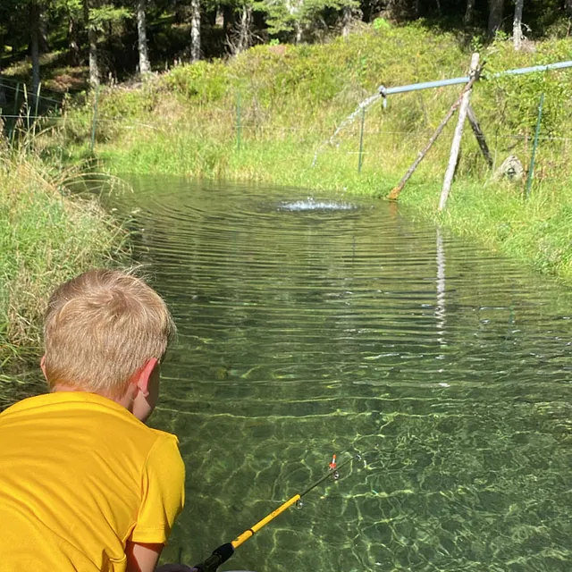 Kind angelt im hausnahen Teich